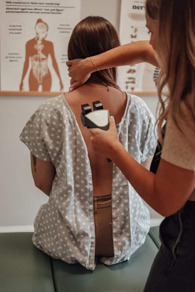 Woman receiving INSiGHT nervous system scan at The Chiro Co in Grapevine, TX, emphasizing holistic chiropractic care and stress analysis.